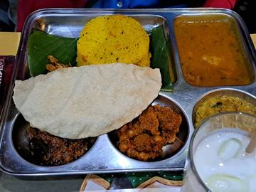 Un plateau servi à table, posé sur le set de table Krishna Bhavan