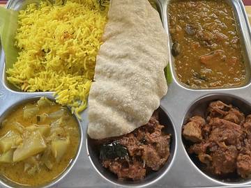 Plateau d'inox garni: riz jaune, papadam et plats en sauce